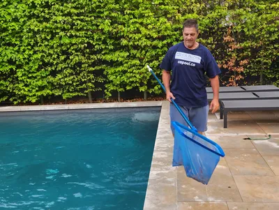 CA Pool Team Member cleaning a pool